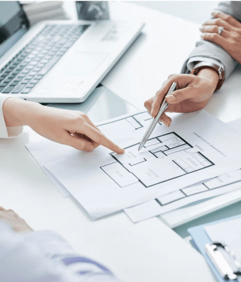 Two people are pointing at a plan on paper.